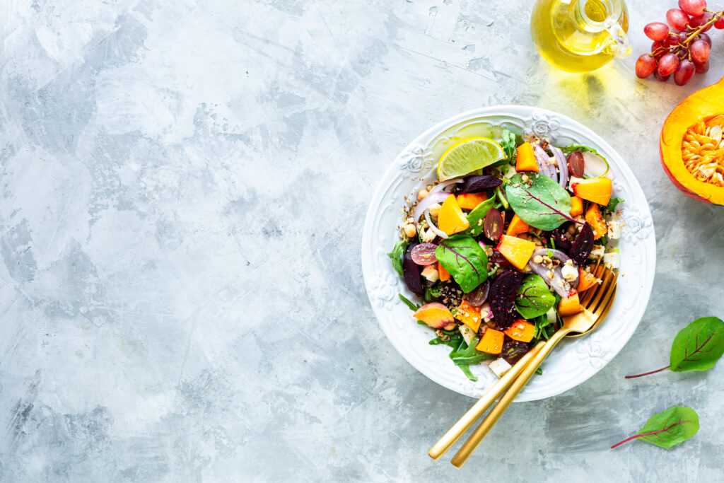 Salad of fresh vegetables with beetroot, arugula and red onion. Top View